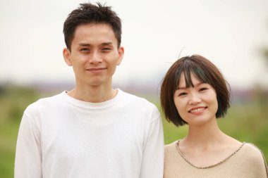 Güneşli bahar gününde parkta duran genç çift