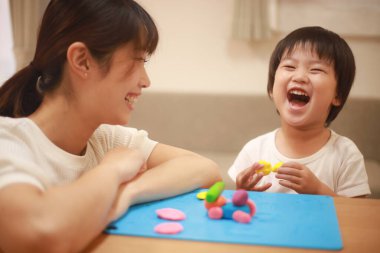 Anne ve oğlu çamurla oynuyor.