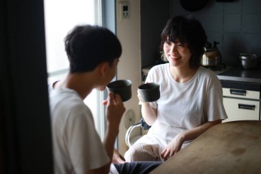 Mutlu genç çift sabahları taze çayın tadını çıkarıyor.