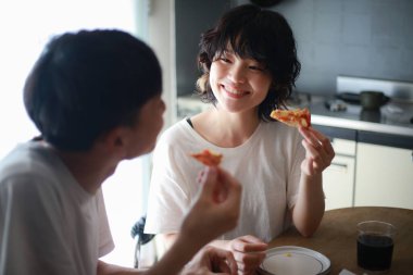 Genç Asyalı çift kahvaltılarını evde yapıyorlar.