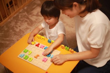 Anne ve oğlu evde oyuncak bloklarıyla oynuyorlar.