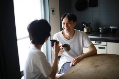 Mutlu genç çift sabahları taze çayın tadını çıkarıyor.