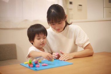 Anne ve oğlu çamurla oynuyor.