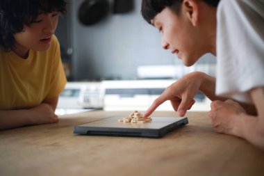 Mutlu Asyalı çift masa oyunu oynuyor.