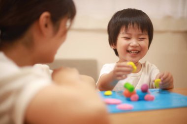 Anne ve oğlu çamurla oynuyor.