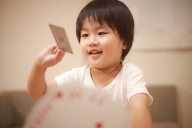 İskambil oynayan Asyalı küçük çocuk. 