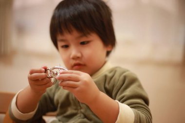 Küçük çocuk bir oyuncakla oynuyor.