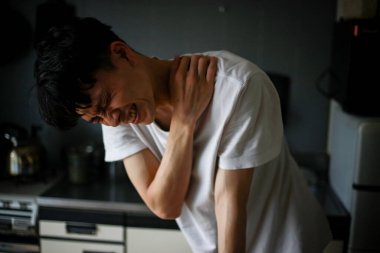 Sırtı ağrıyan üzgün Asyalı adam. 