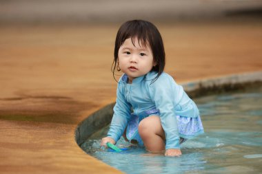 Suda yüzen Asyalı küçük çocuk. 