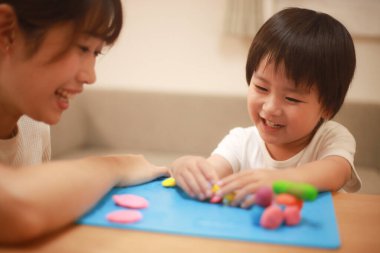 Anne ve oğlu çamurla oynuyor.