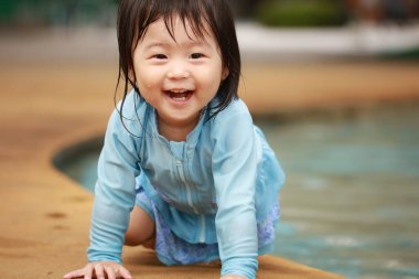 Suda yüzen Asyalı küçük çocuk. 