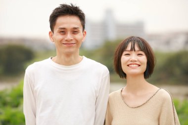 Güneşli bahar gününde parkta duran genç çift