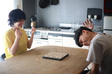 Mutlu Asyalı çift masa oyunu oynuyor.