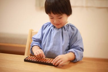 Küçük çocuk evde eğitim oyunu oynuyor.  