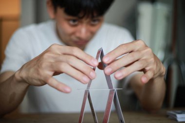 Masada kart oynayan Asyalı adam.