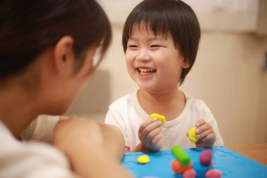 Anne ve oğlu çamurla oynuyor.