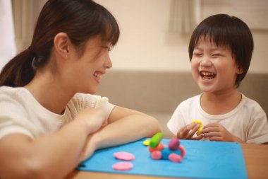 Anne ve oğlu çamurla oynuyor.