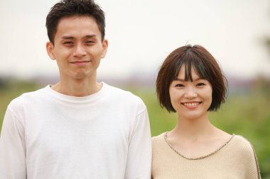 Güneşli bahar gününde parkta duran genç çift