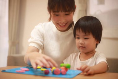 Anne ve oğlu çamurla oynuyor.