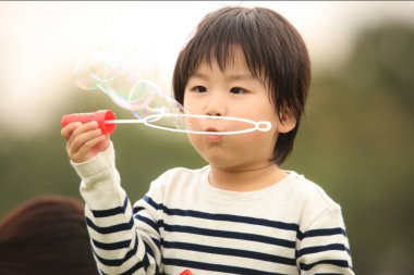 Sabun şişiren bir çocuk.