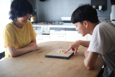Mutlu Asyalı çift masa oyunu oynuyor.