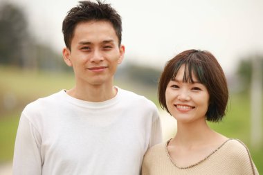 Güneşli bahar gününde parkta duran genç çift