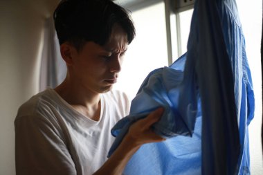 Giysilerin kokusunu önemseyen bir adam.