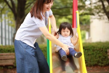 Anne ve kızı oyun alanında oynuyorlar.