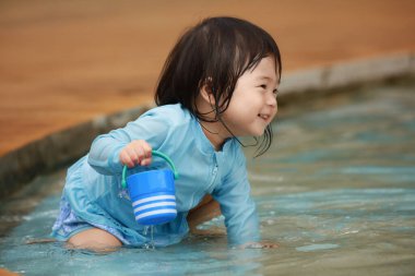 Suda yüzen Asyalı küçük çocuk. 