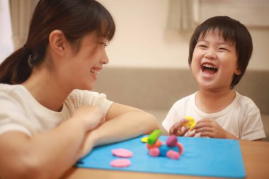 Anne ve oğlu çamurla oynuyor.