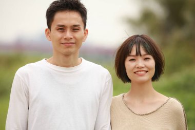 Güneşli bahar gününde parkta duran genç çift