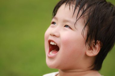 Bulanık arka planda Asyalı bir çocuğun portresi.