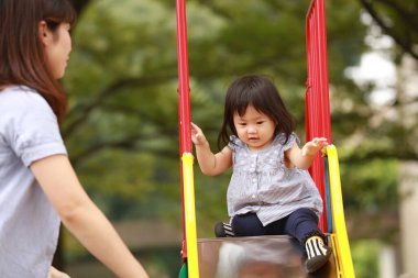 Anne ve kızı oyun alanında oynuyorlar.