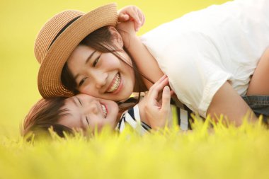 Mutlu anne ve oğul çimenlerde oynuyorlar.