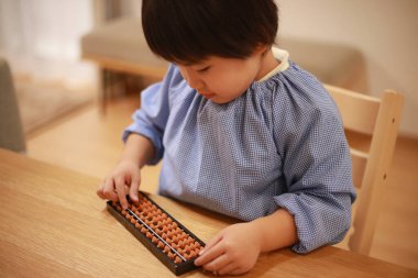 Küçük çocuk evde eğitim oyunu oynuyor.  