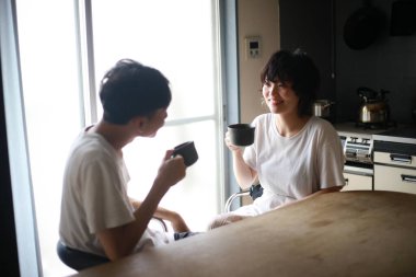 Mutlu genç çift sabahları taze çayın tadını çıkarıyor.