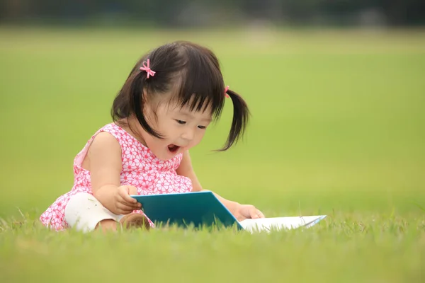 Schattig Klein Meisje Spelen Met Boek Het Park — Stockfoto