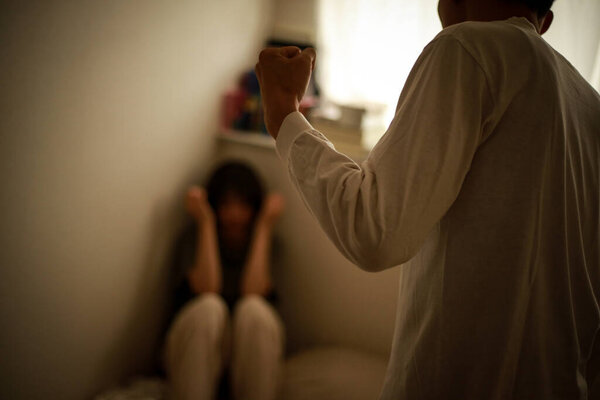  male fist, angry man and scared woman in the background