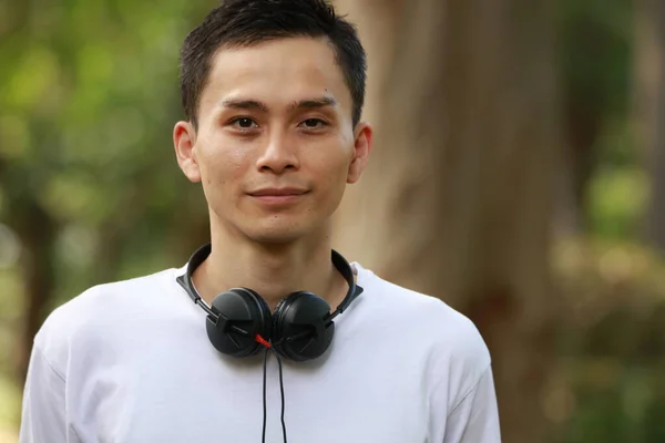 Ung Asiatisk Man Med Hörlurar Parken — Stockfoto