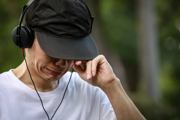 Smutný Asijský Muž Poslouchající Hudbu Parku — Stock fotografie
