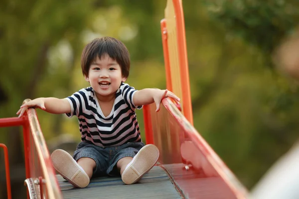Çocuk parkında oynayan şirin bir çocuk.
