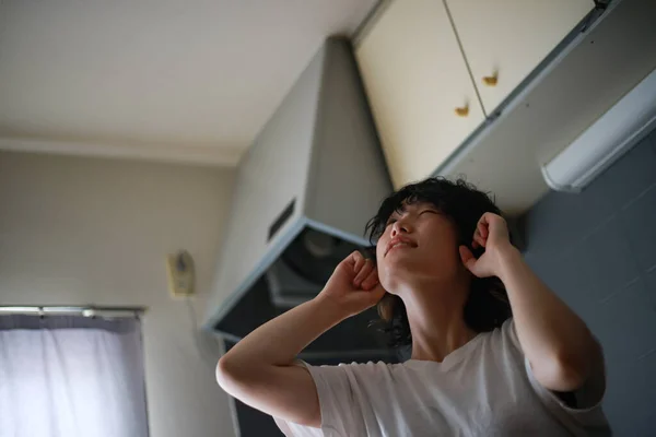 2階の騒音に苦しむアジアの女性 — ストック写真