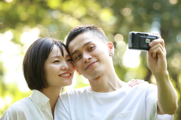 Mutlu çift parkta fotoğraf çekiyor.