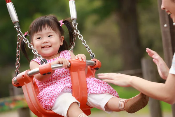 Anne ve kızı oyun alanında oynuyorlar.