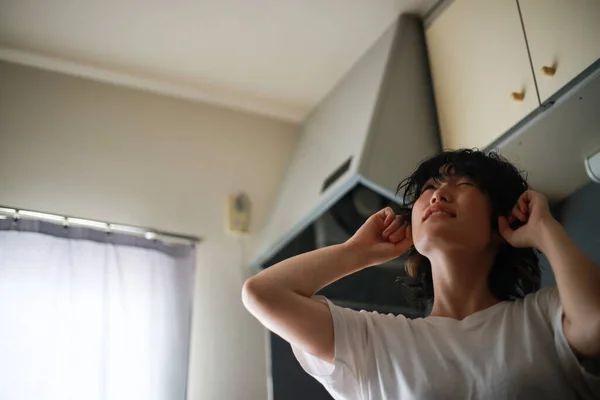 2階の騒音に苦しむアジアの女性 — ストック写真