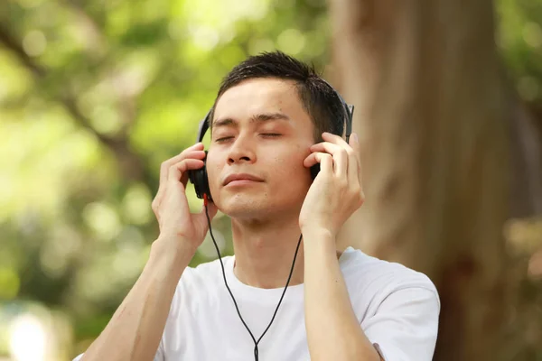 Aziatische Man Luisteren Naar Muziek Het Park — Stockfoto