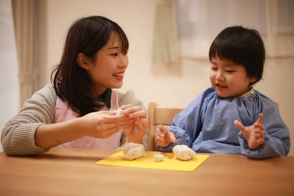 Küçük çocuk ve annesi mangırla oynuyorlar. 