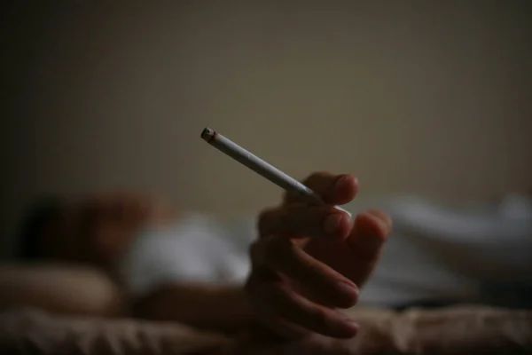 Férfi Cigarettával Feküdt Ágyban — Stock Fotó