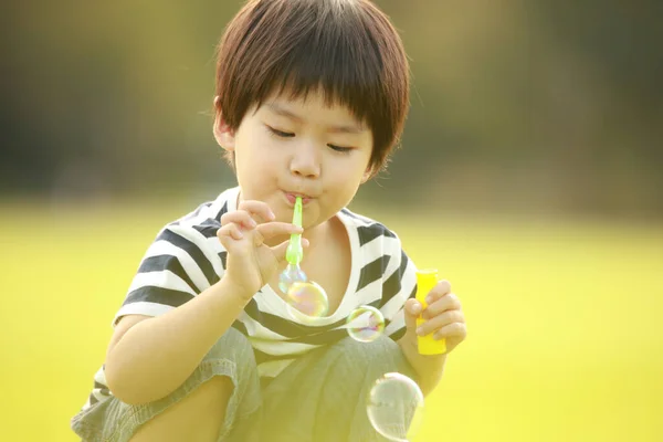 屋外の公園でシャボン玉を持ったアジア系の男の子 — ストック写真