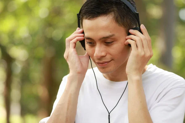 Aziatische Man Luisteren Naar Muziek Het Park — Stockfoto